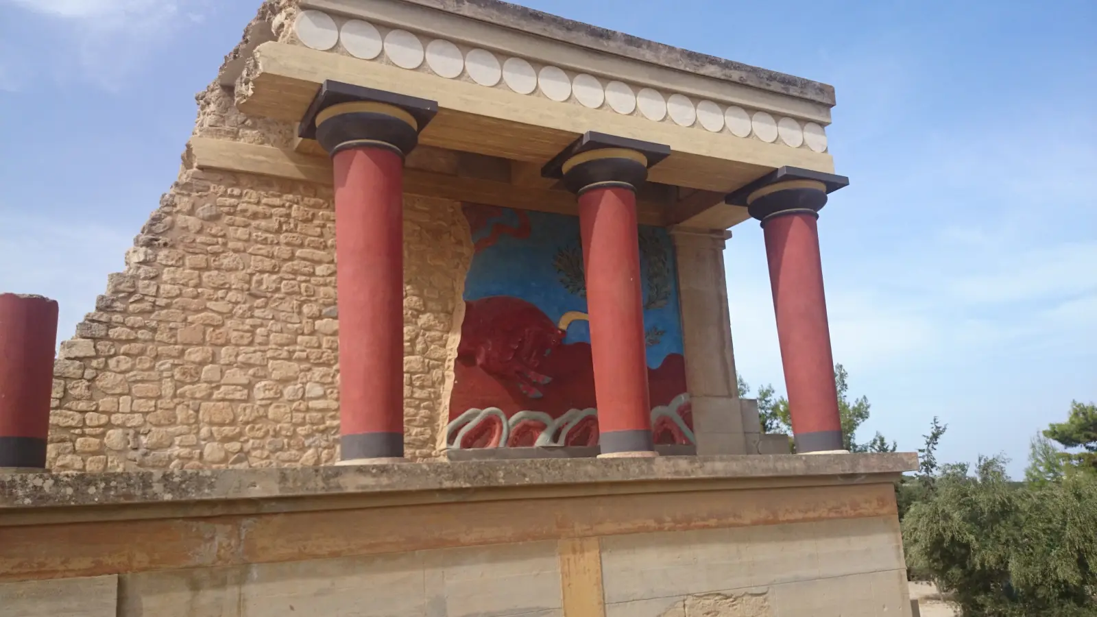 Reconstructed red columns and bull fresco at the Palace of Knossos on Crete.