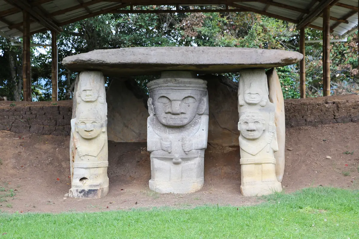 Carved stone figures supporting a burial slab at Mesita A in San Agustín Archaeological Park, Colombia.