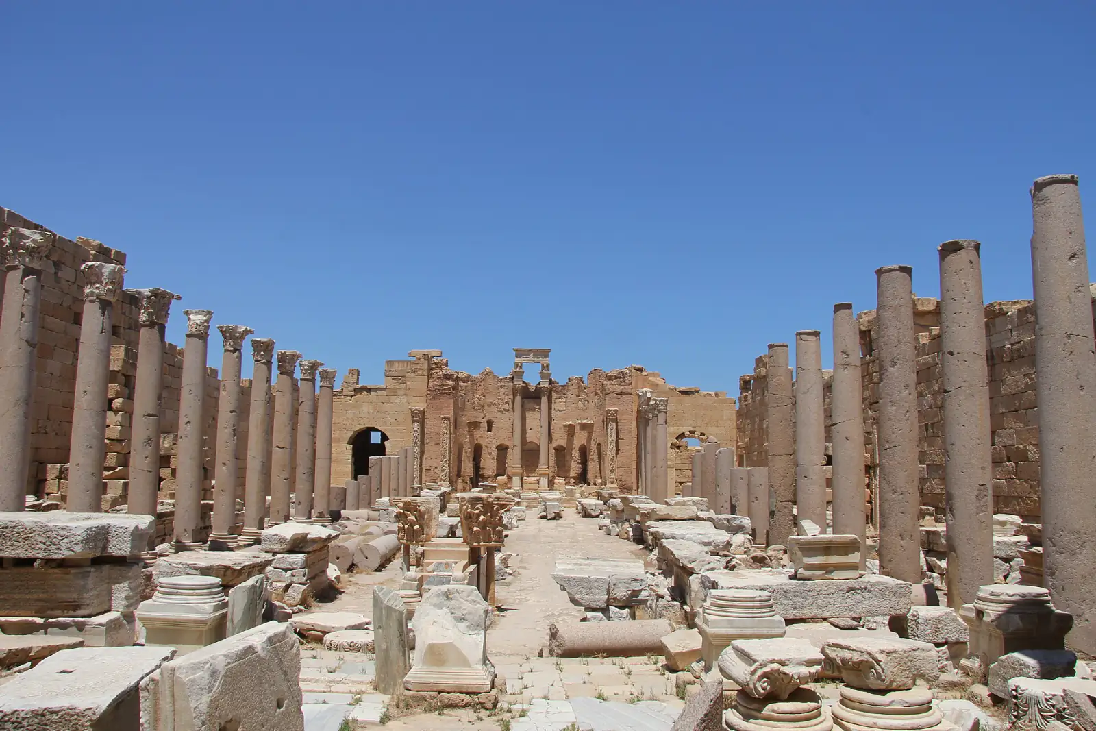 Rows of standing columns and carved architectural fragments at the Roman city of Leptis Magna in Libya.